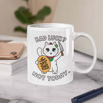 A coffee mug with a Maneki Neko Millie the Cat with the text: Bad Luck? Not today.