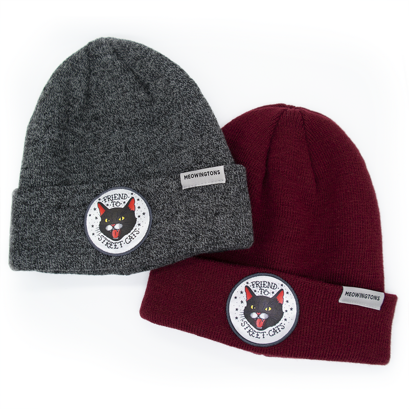 This cat beanie hat features a snarling black cat patch on the fold-over cuff with text that reads "Friend to Street Cats." 
